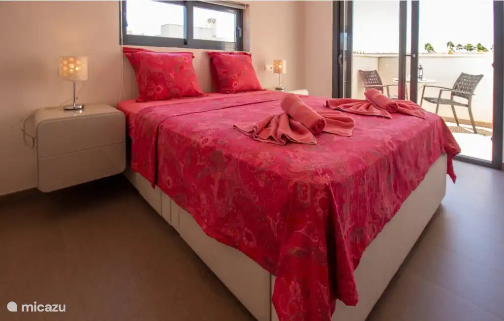 Slaapkamer met tweepersoonsbed en charmant terrasje
